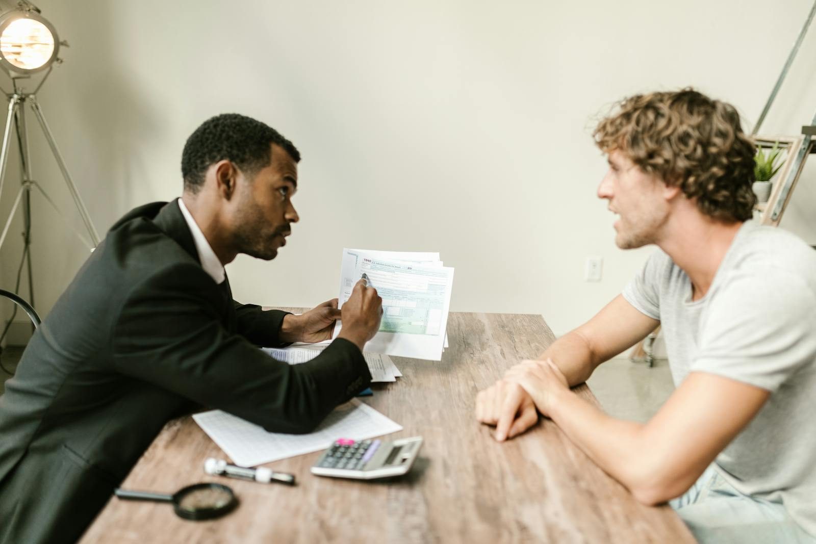 A financial advisor reviewing paperwork with a client at a desk