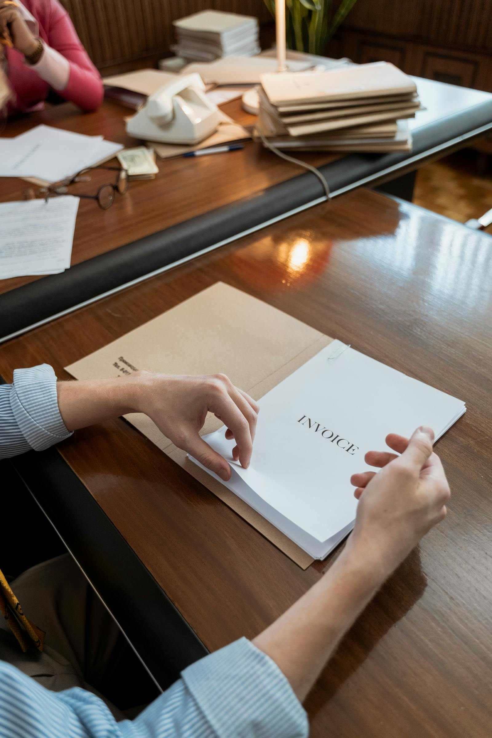 Hands sorting invoices on an office desk