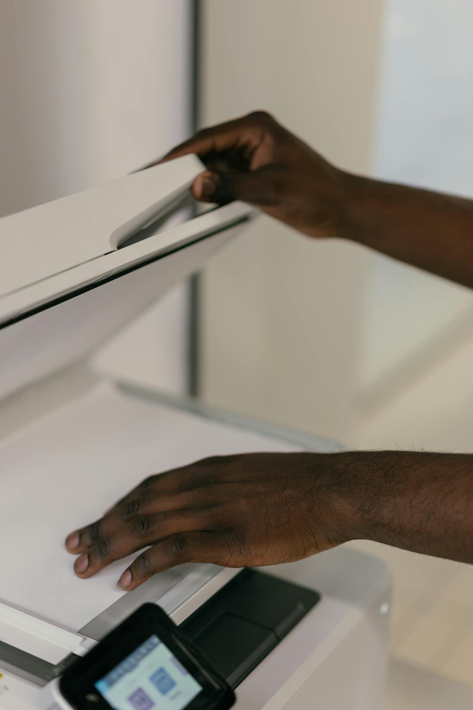 Hands placing a document on a scanner in an office