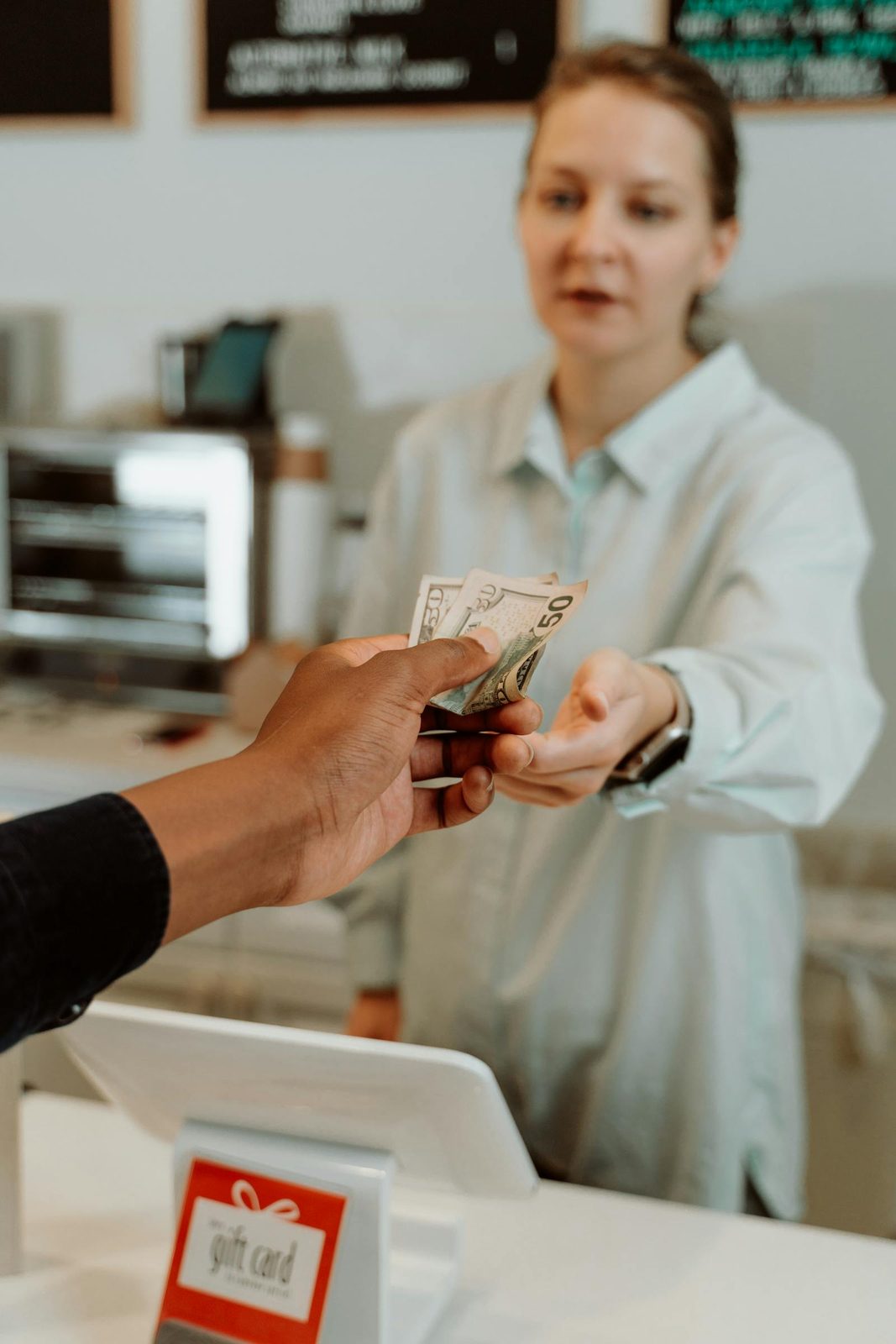 Cashier receiving a cash payment from a customer at a service counter