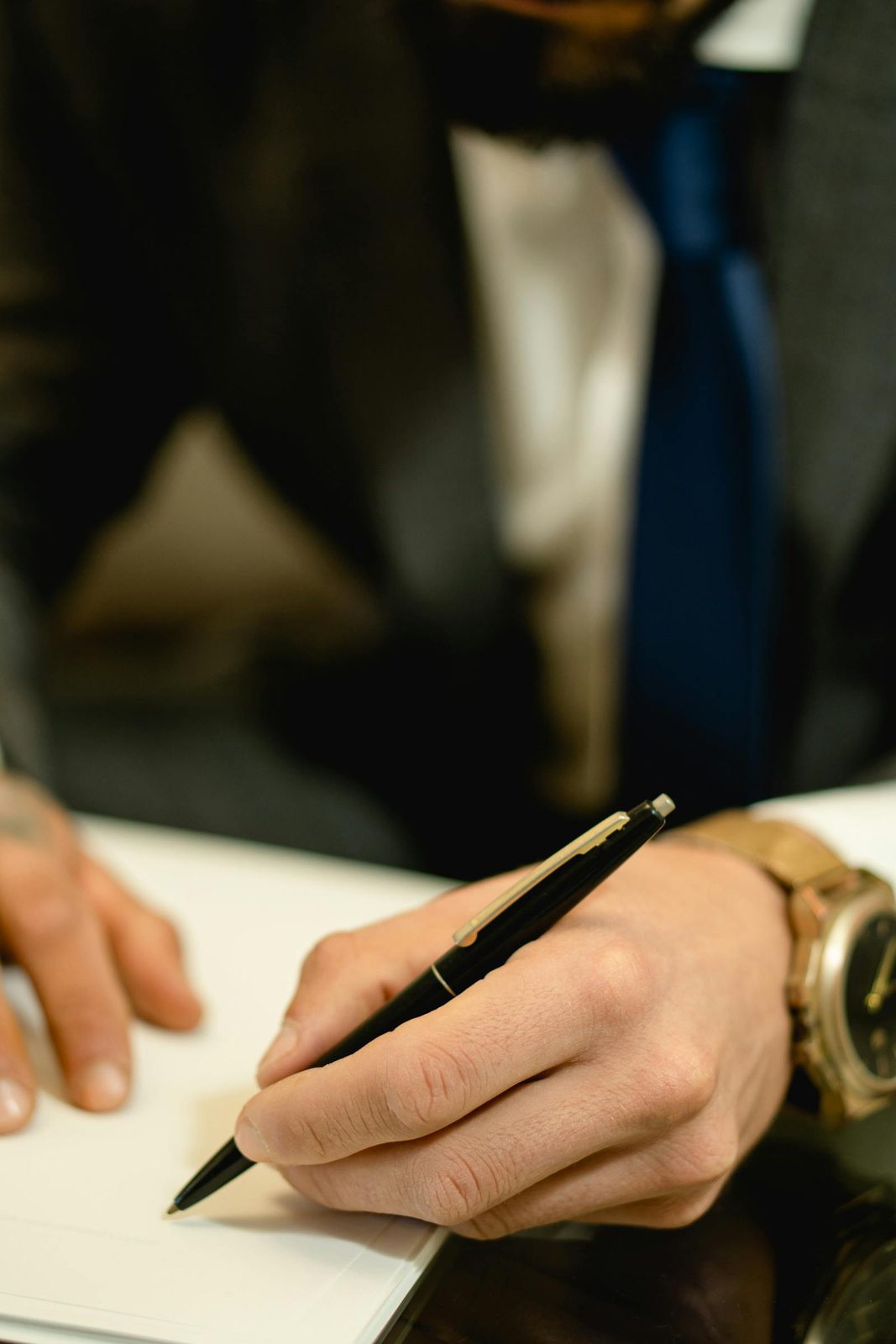 Close-up of a hand signing a legal document with a pen